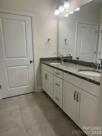 a bathroom with a granite countertop sink a mirror and a vanity