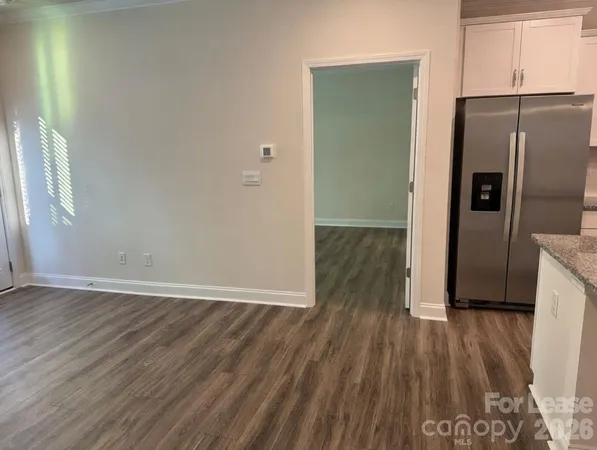 a view of a kitchen with wooden floor and a refrigerator