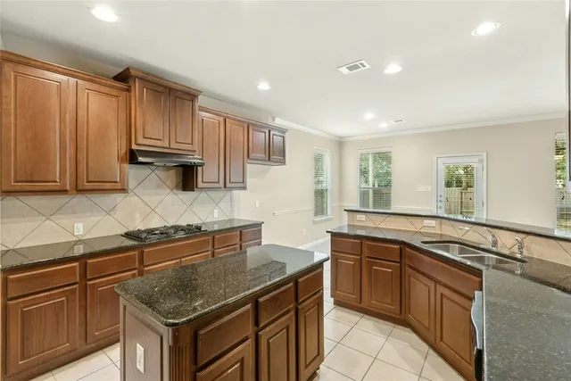 a kitchen with granite countertop a sink stove and cabinets