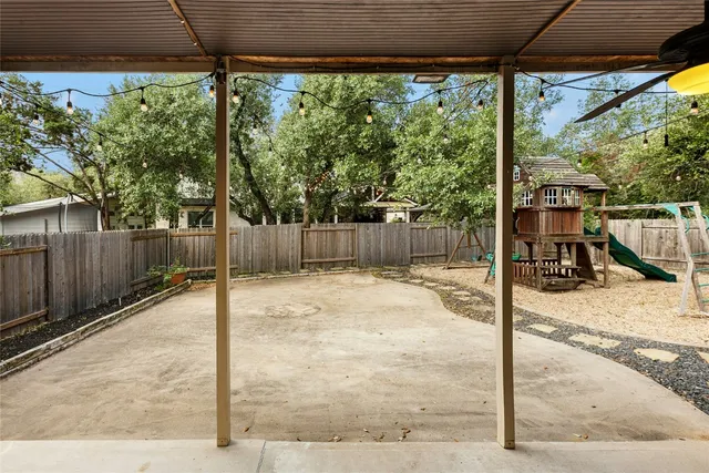 a view of a backyard with wooden floor and floor to ceiling window and wooden fence
