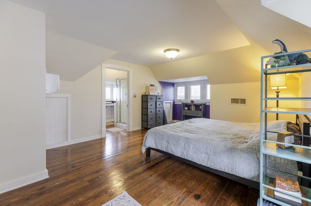 a living room with kitchen island a wooden floor and large windows