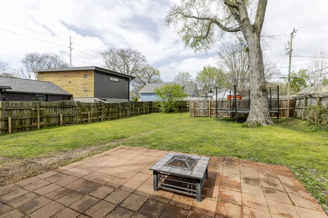 a view of a backyard with couches plants and large tree