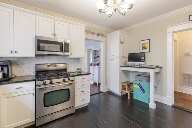 a kitchen with stainless steel appliances a stove cabinets and wooden floor