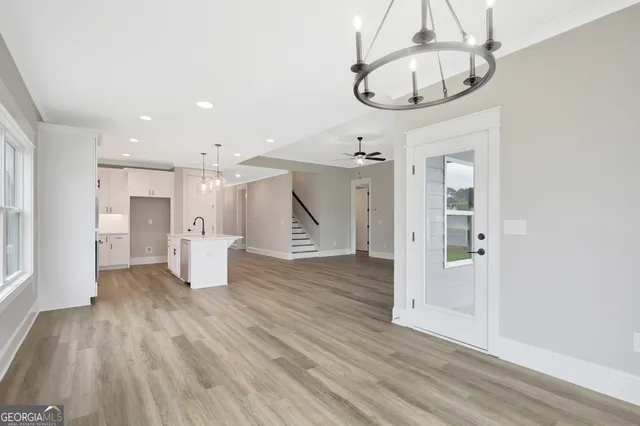 a view of a livingroom with wooden floor and a chandelier