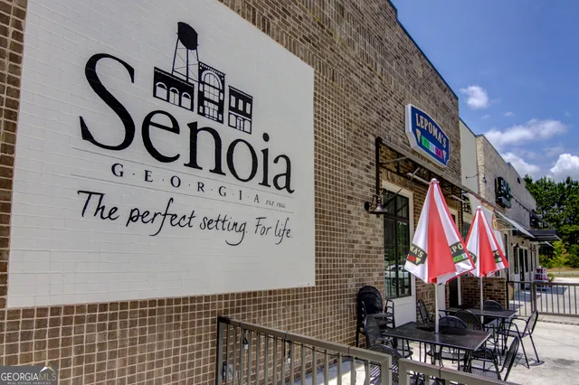 a front view of a building with a garden and plants