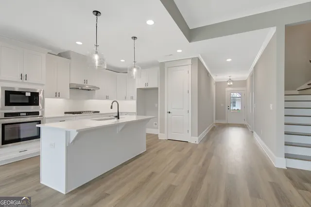 a view of kitchen with sink and refrigerator
