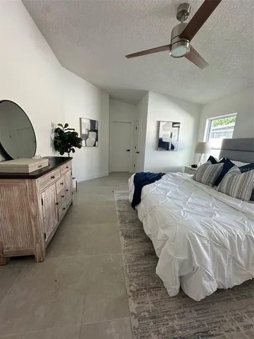 an empty room with windows and ceiling fan