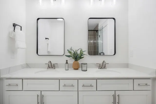 a bathroom with vanity sinks and a mirror