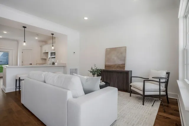 a living room with furniture and a dining table with wooden floor