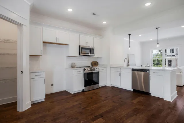 a kitchen with white cabinets and stainless steel appliances