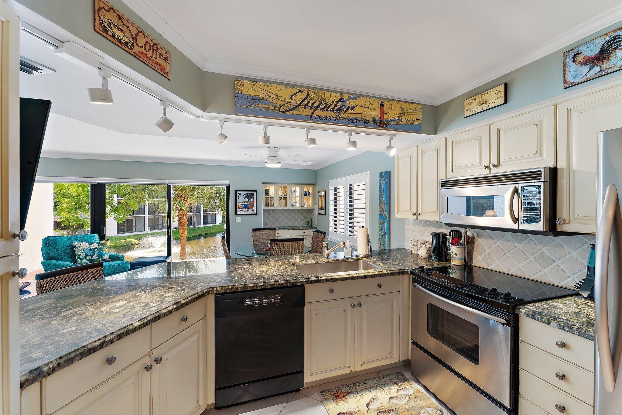 1605 Us-1, Unit B206 Jupiter, FL 33477 - Photo 14 of 35 a kitchen with granite countertop stainless steel appliances a sink and cabinets