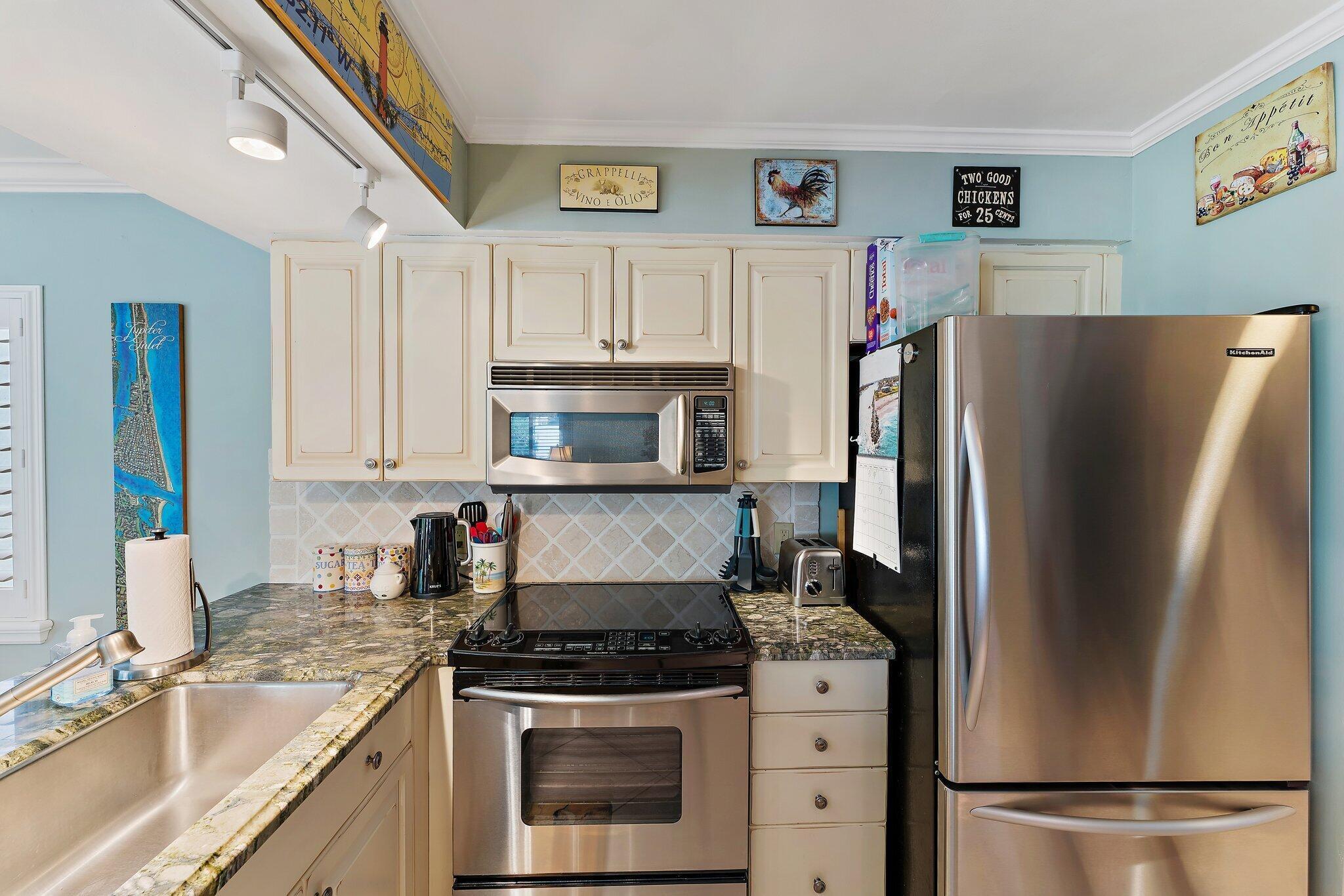 1605 Us-1, Unit B206 Jupiter, FL 33477 - Photo 15 of 35 a kitchen with stainless steel appliances granite countertop a refrigerator sink and stove