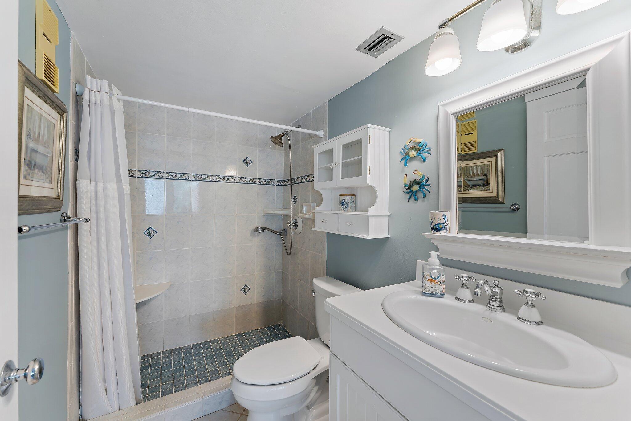 1605 Us-1, Unit B206 Jupiter, FL 33477 - Photo 27 of 35 a bathroom with a sink a toilet and shower