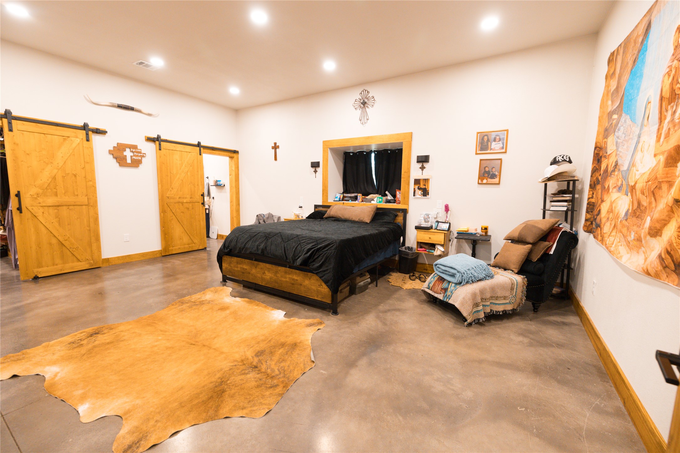 143 County Road Paige, TX 78659 - Photo 18 of 36 Master Bedroom on first floor featuring concrete flooring, recessed lighting, and a barn doors