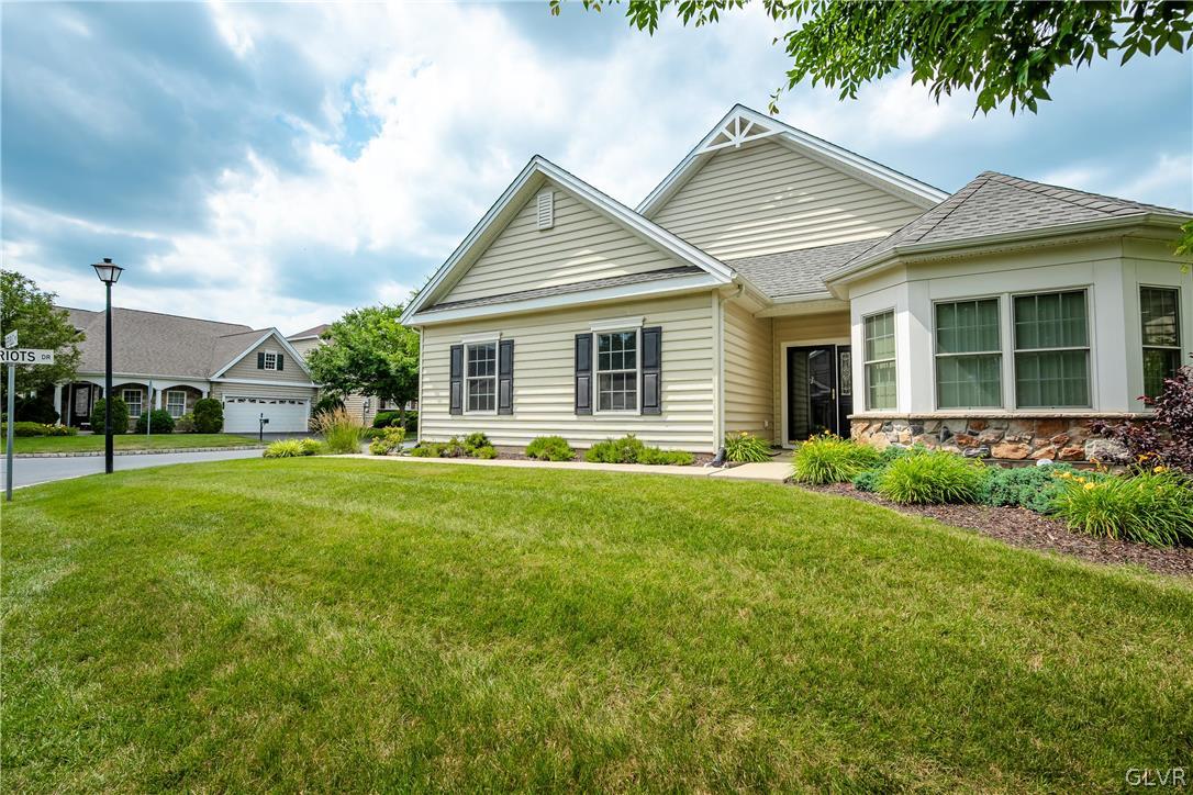 a view of a house with a yard and lawn chairs