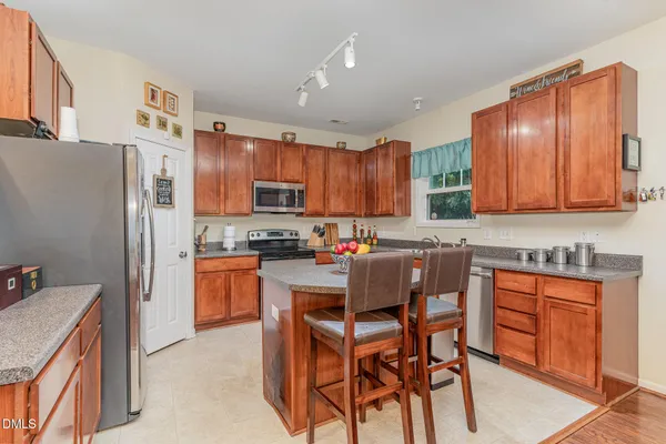 a kitchen with stainless steel appliances granite countertop a refrigerator a stove top oven a sink and dishwasher