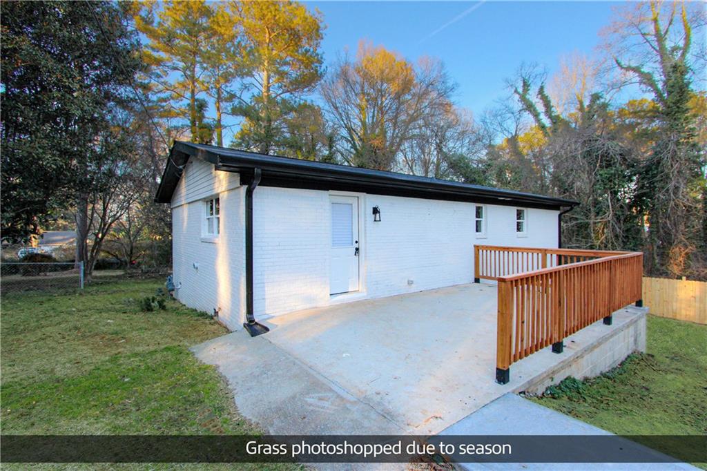 a view of backyard with tree and wooden fence