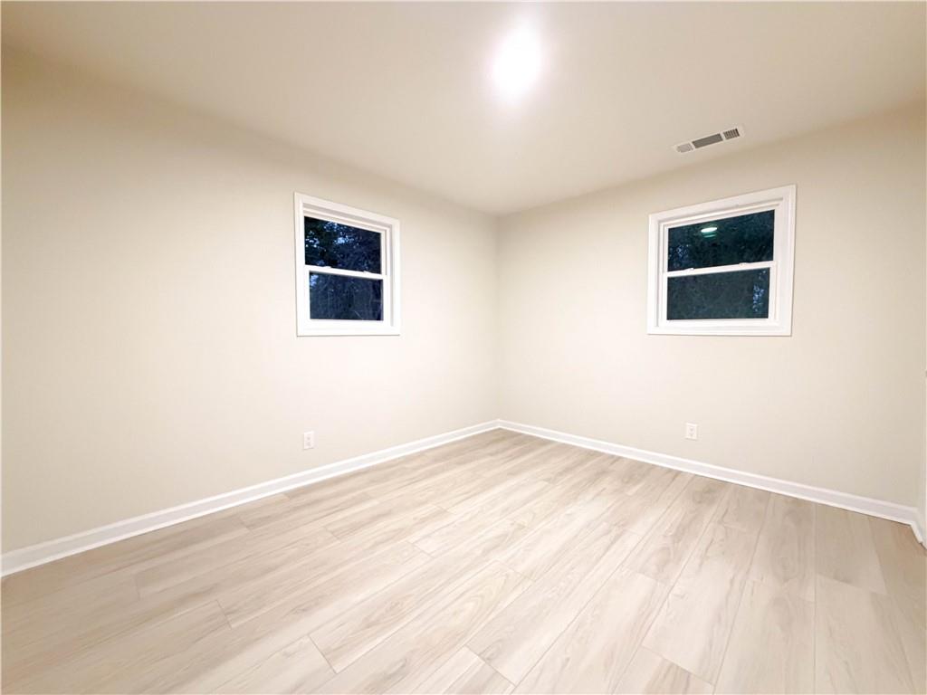 102 Welch Street Stockbridge, GA 30281 - Photo 16 of 28 an empty room with wooden floor and windows