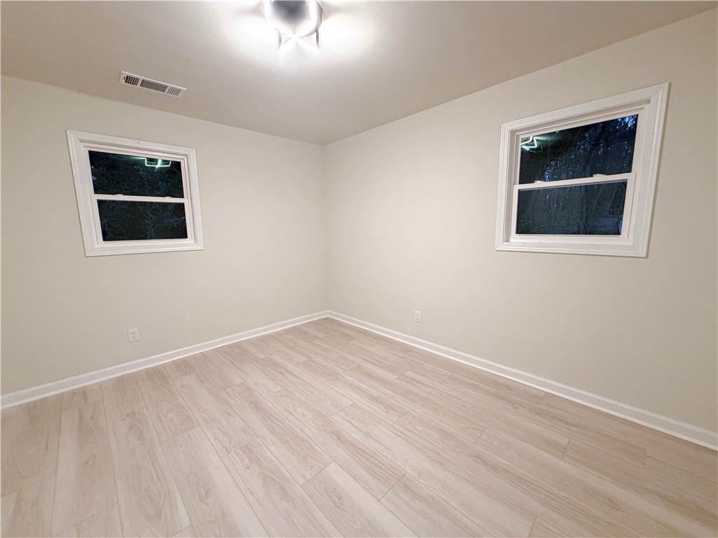 102 Welch Street Stockbridge, GA 30281 - Photo 18 of 28 a view of an empty room with wooden floor and a window