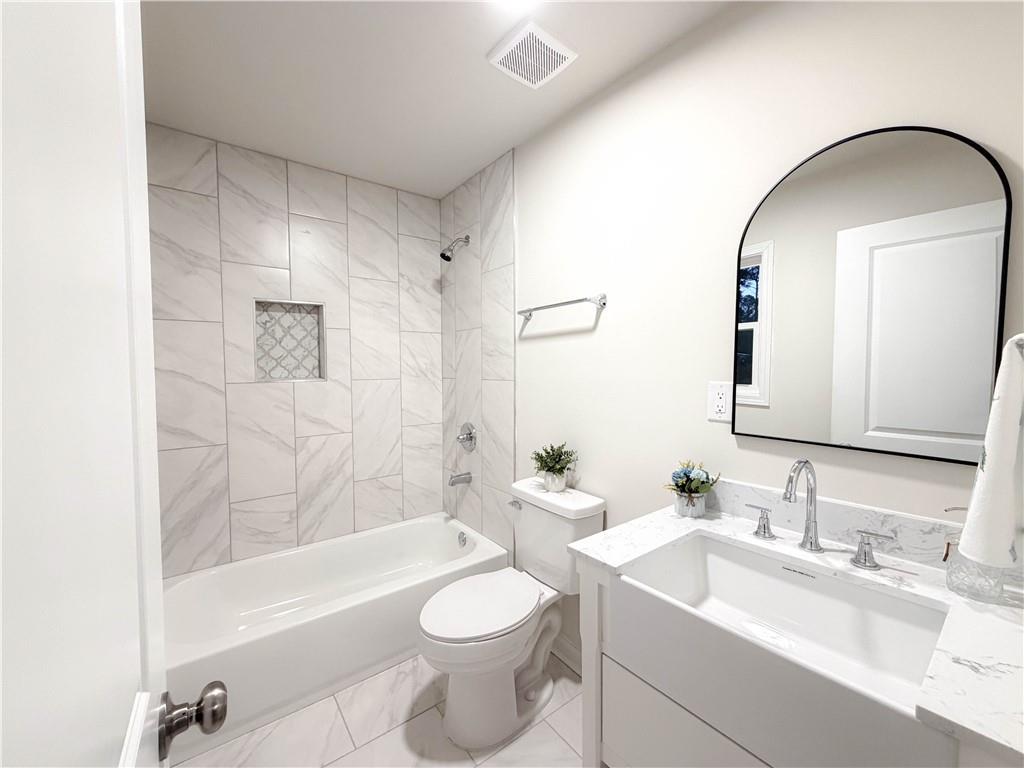102 Welch Street Stockbridge, GA 30281 - Photo 20 of 28 a bathroom with a bathtub shower sink mirror vanity and toilet