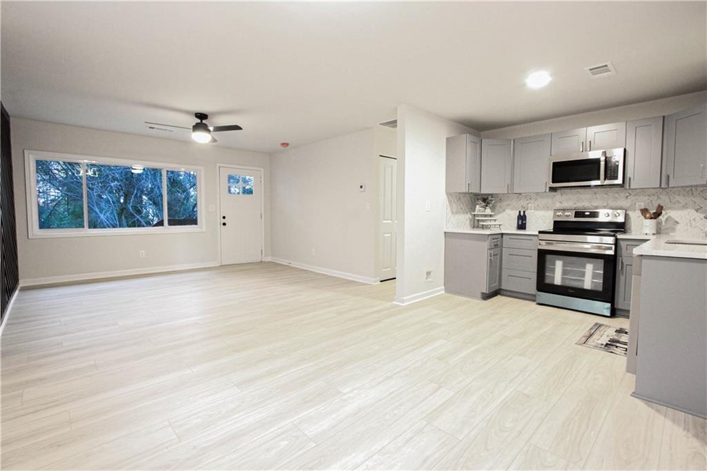 102 Welch Street Stockbridge, GA 30281 - Photo 4 of 28 a large white kitchen with cabinets and wooden floor