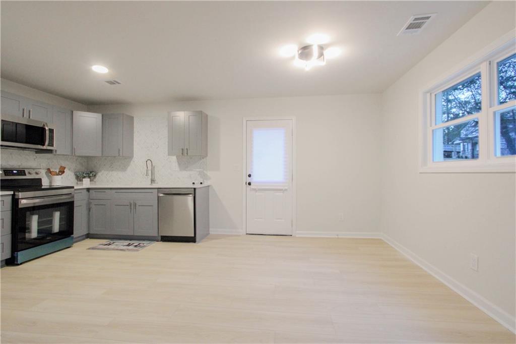 102 Welch Street Stockbridge, GA 30281 - Photo 8 of 28 a kitchen with granite countertop a stove a sink and a refrigerator