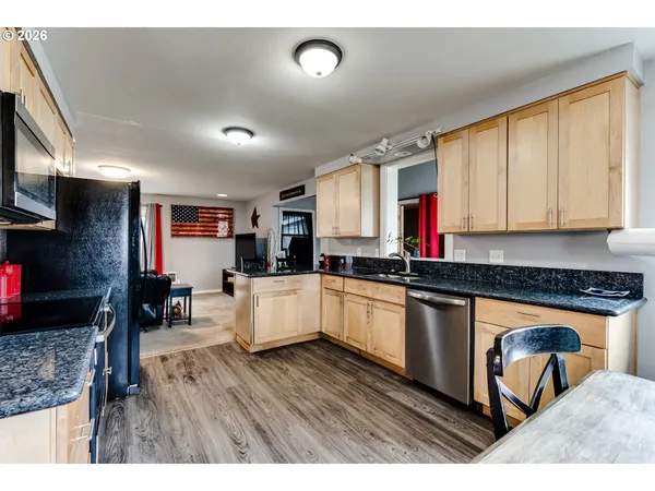 a open kitchen with stainless steel appliances granite countertop a stove refrigerator and cabinets