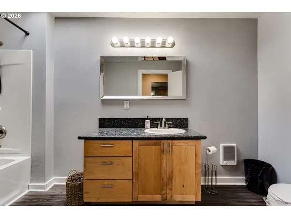 a bathroom with a sink a bathtub and a mirror
