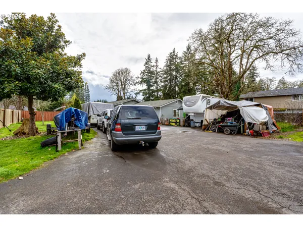 a car parked in front of a house next to a yard