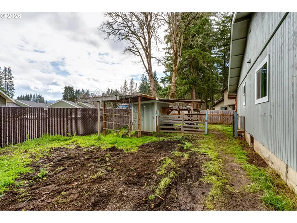 a view of backyard with wooden fence