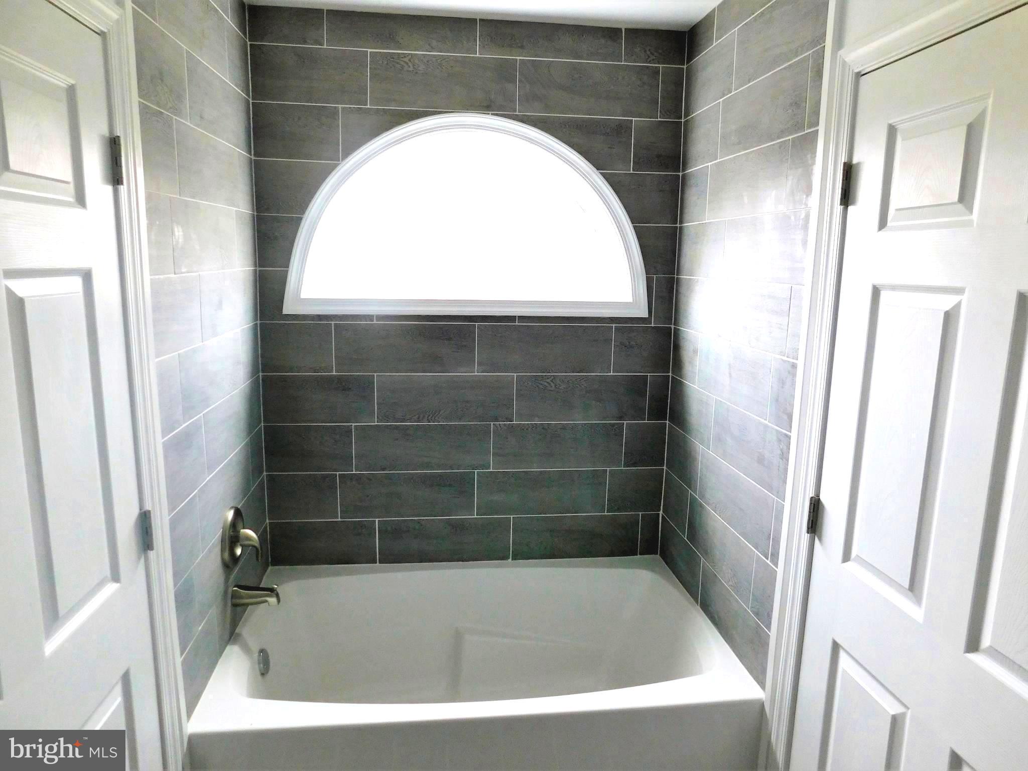 2 Whaleys Road Delmar, DE 19940 - Photo 19 of 28 a bathroom with a tub a window and a glass door shower