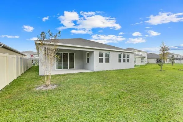 a view of a house with backyard and a tree