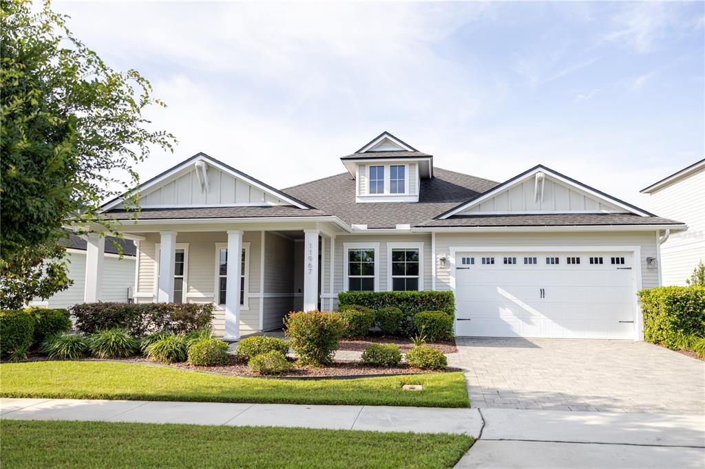 a front view of a house with a yard and potted plants