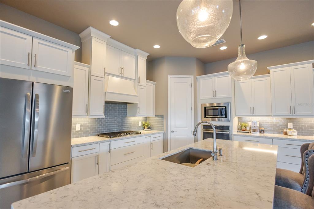 11967 Southwest 32nd Lane Gainesville, FL 32608 - Photo 16 of 22 a kitchen with stainless steel appliances granite countertop a refrigerator and a stove top oven