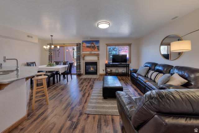3461 Westwater Road, Unit 6 Moab, UT 84532 - Photo 7 of 33 Living room featuring a tile fireplace, dark wood-type flooring, and suspended lighting