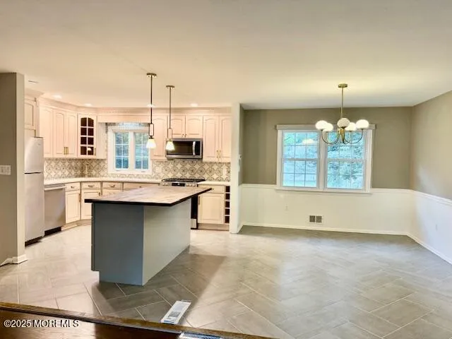 a kitchen with kitchen island granite countertop a stove a sink and a refrigerator
