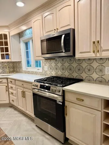 a kitchen with stainless steel appliances granite countertop a stove microwave and cabinets
