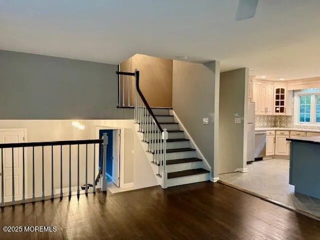 a view of a hallway with wooden floor and staircase
