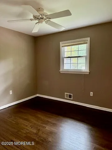 a view of a room with wooden floor and fan