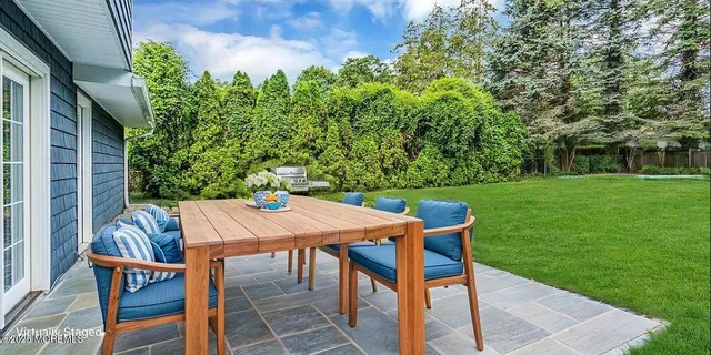 a table and chairs with the view of tree