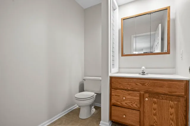 a bathroom with a toilet a sink and mirror