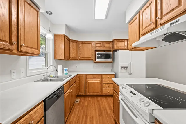 a kitchen with granite countertop a sink a counter space appliances and cabinets