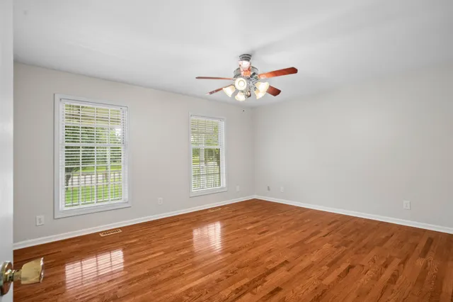 an empty room with a window and a fan