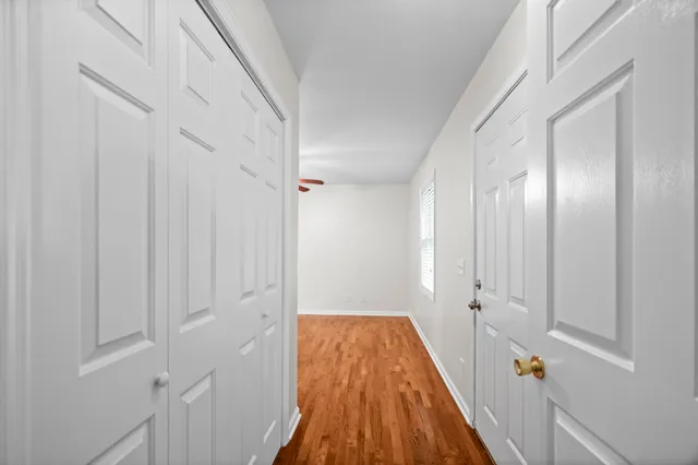 a view of a hallway with wooden floor and staircase