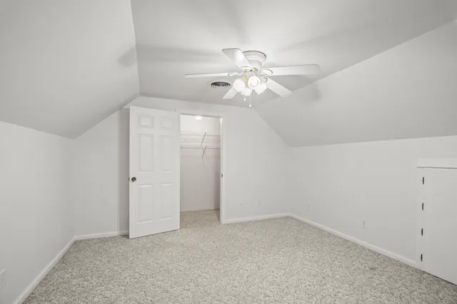 an empty room with a window and a ceiling fan