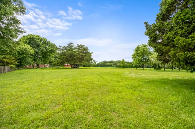 a view of a green field with wooden fence