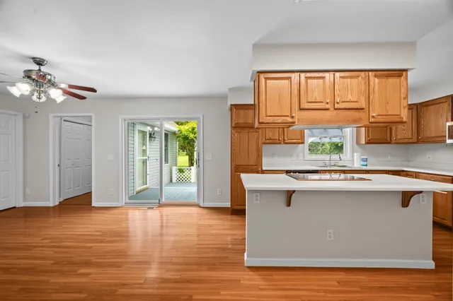 a kitchen with stainless steel appliances granite countertop a stove a sink dishwasher and a microwave with wooden floor