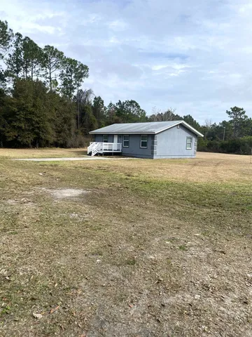 a view of an house with backyard space and balcony