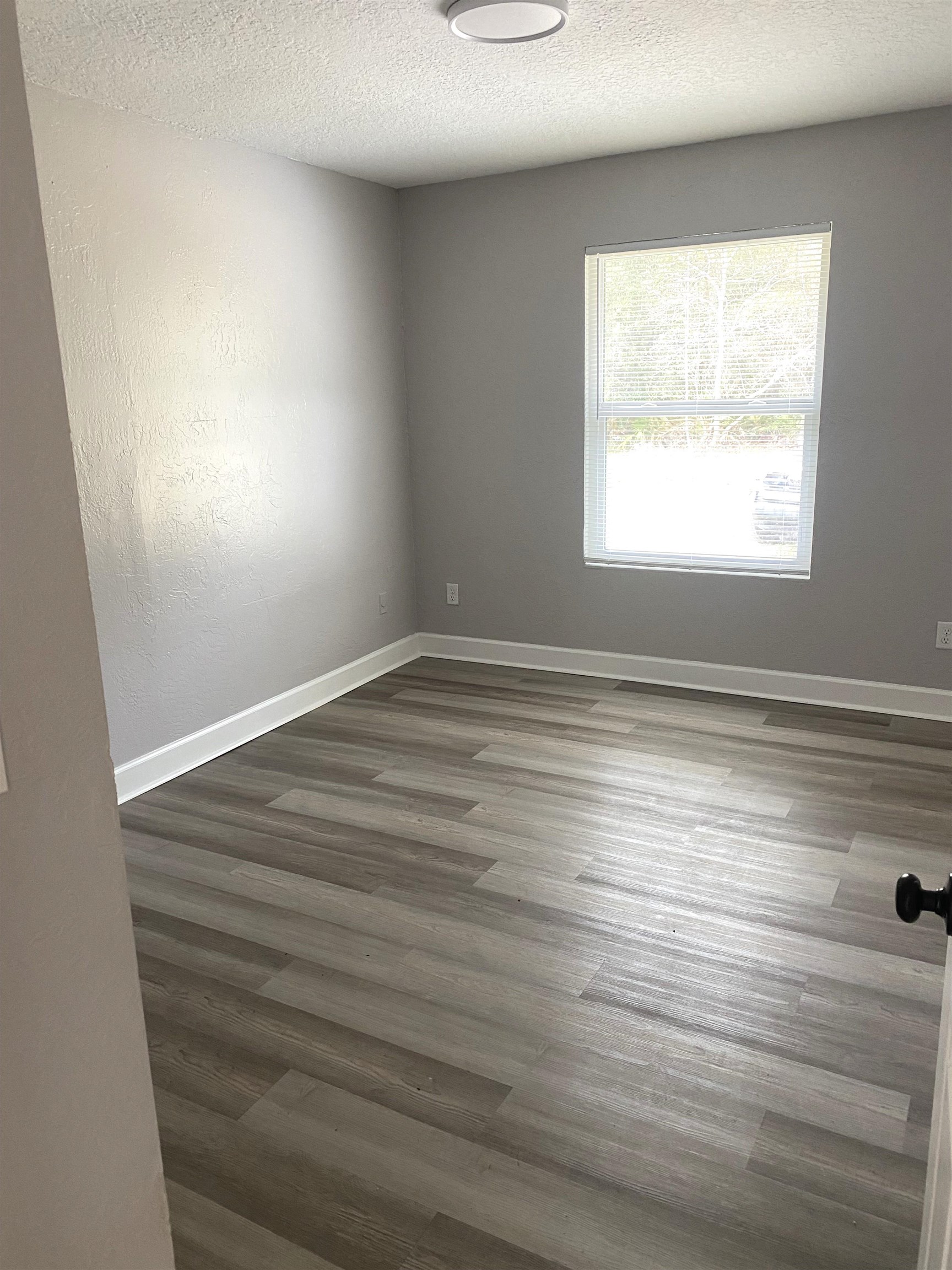 1870 Adams Acres Road St. Augustine, FL 32084 - Photo 4 of 12 Empty room with a textured ceiling, wood finished floors, and a textured wall