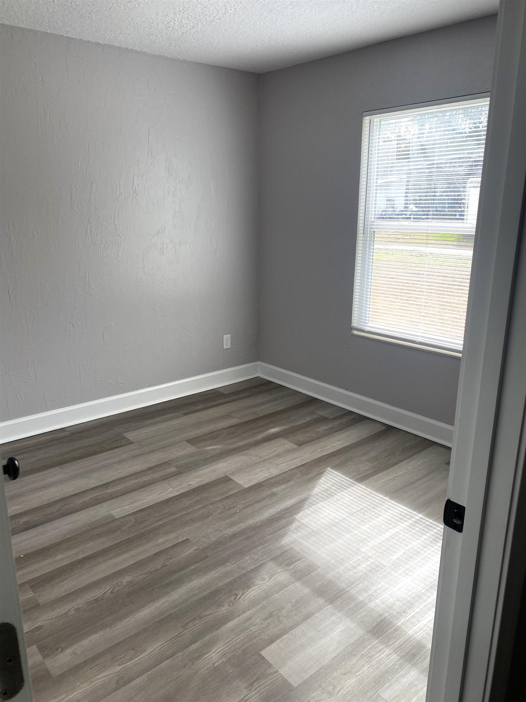 1870 Adams Acres Road St. Augustine, FL 32084 - Photo 8 of 12 Empty room featuring a textured ceiling, light wood-type flooring, and a textured wall